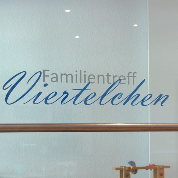 Familientreff Viertelchen Text auf Glasfenster: "Familientreff Viertelchen" in blauer Schrift.